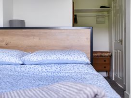 A bedroom with a bed and wardrobe at The Nook in Praa Sands