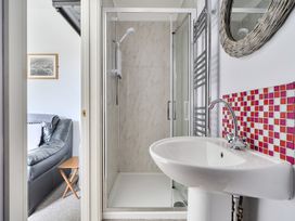 A bathroom featuring a shower, sink, and towel radiator at The Nook in Praa Sands