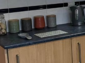A kitchen countertop with storage jars and a kettle at 