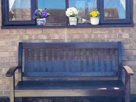 A bench with potted plants in front of a window at an unspecified location