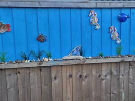 A blue fence with decorative fish and seahorses at an outdoor location