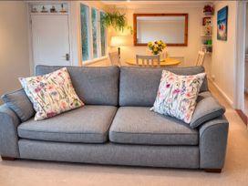 A living room with a sofa and dining table at Quackers Heacham