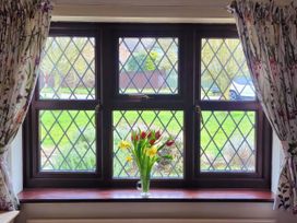 A window with flowers and a view of the garden at Quackers in Heacham