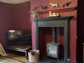 A living room with a television and fireplace at High Dyke Cottage