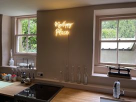 A kitchen with a neon sign and bottles at High Dyke Cottage