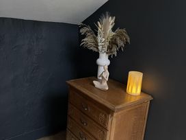 A cabinet with a vase and dried flowers at High Dyke Cottage in 