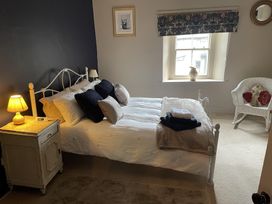 A bedroom with a bed and lamp at High Dyke Cottage in 