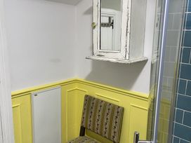 A bathroom with a chair and a mirror cabinet at High Dyke Cottage