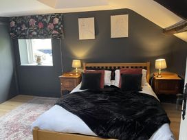 A bedroom with a bed and bedside tables at High Dyke Cottage