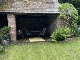An outdoor seating area with a table and chairs at High Dyke Cottage 