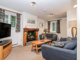 A living room with a fireplace and TV at Orchard Cottage in Dawlish