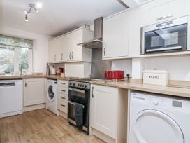 A kitchen with appliances and cabinets at Orchard Cottage in Dawlish