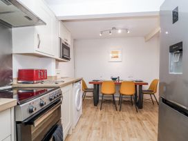 A kitchen with a dining area featuring a table and chairs at Orchard Cottage in Dawlish