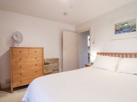 A bedroom with a bed and chest of drawers at Orchard Cottage in Dawlish