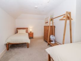 A bedroom with two single beds and a dresser at Orchard Cottage in Dawlish