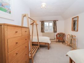 A bedroom with beds and wooden furniture at Orchard Cottage in Dawlish