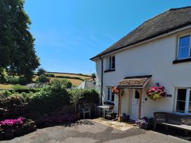 A house with flowers near the entrance at Orchard Cottage in Holcombe