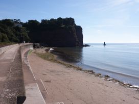 A beach with cliffs and a rock formation at Orchard Cottage Holcombe