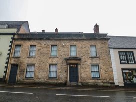 A brick building with windows and a door on a street at ASH HOUSE