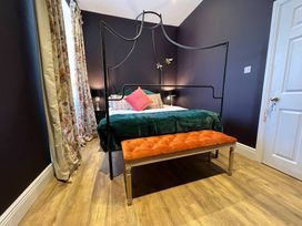 A bedroom with a bed and bench at ASH HOUSE in Wincanton