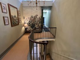 A staircase in a hallway with a mural and framed artwork at ASH HOUSE in Wincanton