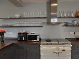 A kitchen with shelves and appliances at ASH HOUSE in Wincanton