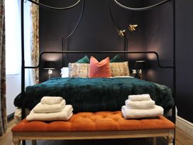 A bedroom with a bed, bench and towels at ASH HOUSE in Wincanton