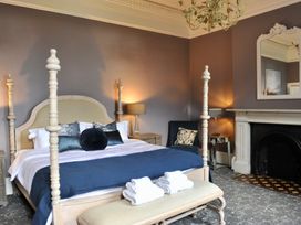 A bedroom with a bed and a fireplace at ASH HOUSE in Wincanton