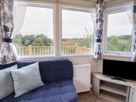 A living room with a sofa and television at caravan NEW in Uplyme