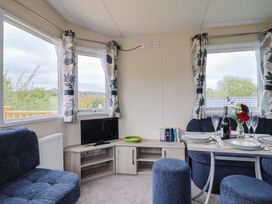 A dining room with a table and sofa at caravan NEW Uplyme