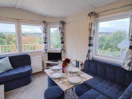 A living room with a dining table and sofa at caravan NEW Uplyme