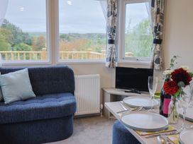 A living room with a couch and dining setup at caravan NEW Uplyme