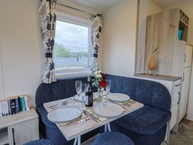 A dining area with a table set for meals at caravan NEW in Uplyme