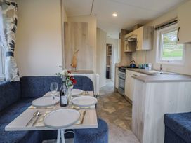 A dining area with a table and chairs at caravan NEW in Uplyme