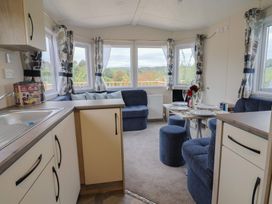 A living room with a dining area and kitchen features at caravan NEW in Uplyme