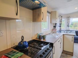 A kitchen featuring a gas stove, kettle, and sink at caravan NEW, Uplyme