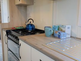 A kitchen with a kettle and cups on the counter at caravan NEW in Uplyme