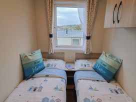 A bedroom with two beds and a window at caravan NEW in Uplyme
