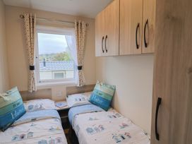 A bedroom with two beds and curtains at caravan NEW in Uplyme