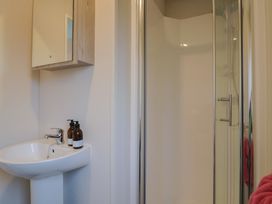 A bathroom with a sink and shower stall at caravan NEW Uplyme