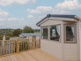 An outdoor area with a cabin and decking at caravan NEW in Uplyme