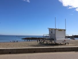 A lifeguard tower on the beach with people and ocean nearby at caravan NEW Uplyme
