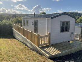 A caravan with a wooden deck in a rural setting at caravan NEW Uplyme