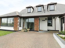 An entrance view of a house with a pathway and plant pots at Chynoweth in Crantock