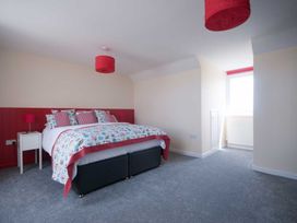 A bedroom with a bed and nightstand at Chynoweth in Crantock