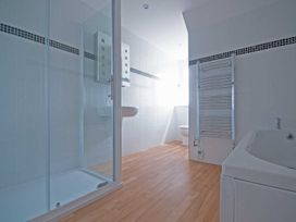 A bathroom with a shower, washbasin, toilet, and towel rail at Chynoweth in Crantock