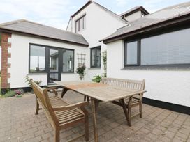 An outdoor patio with a table and chairs at Chynoweth in Crantock