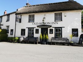 A pub exterior with benches and signage at Old Albion Inn in Crantock