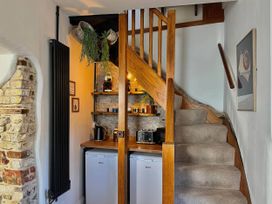 A hallway with a staircase and kitchen appliances at 