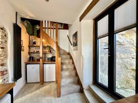 A staircase leading to a kitchen area with a refrigerator and coffee maker at 